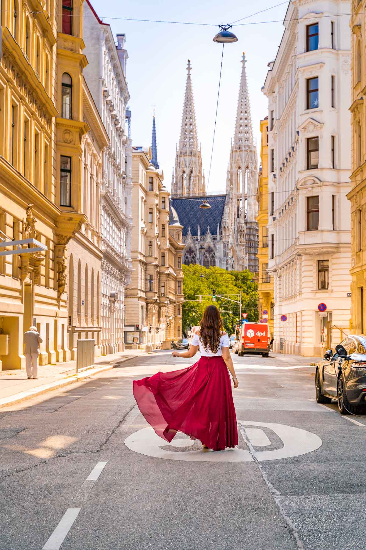 Girl in a red dress on a street with Votivkirche in the background