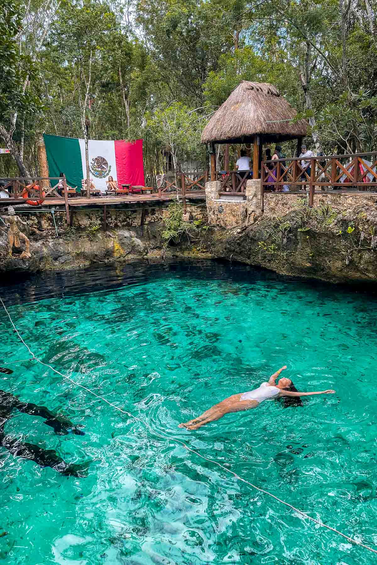 Girl in white swimsuit swimming in Cenote Zacil-Ha