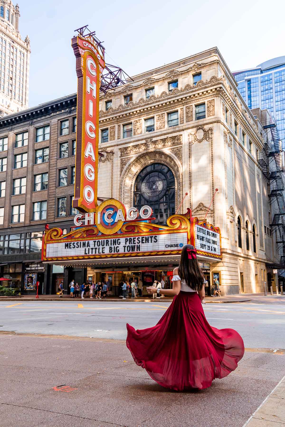 Girl in red dress in front of the Chicago Theatre