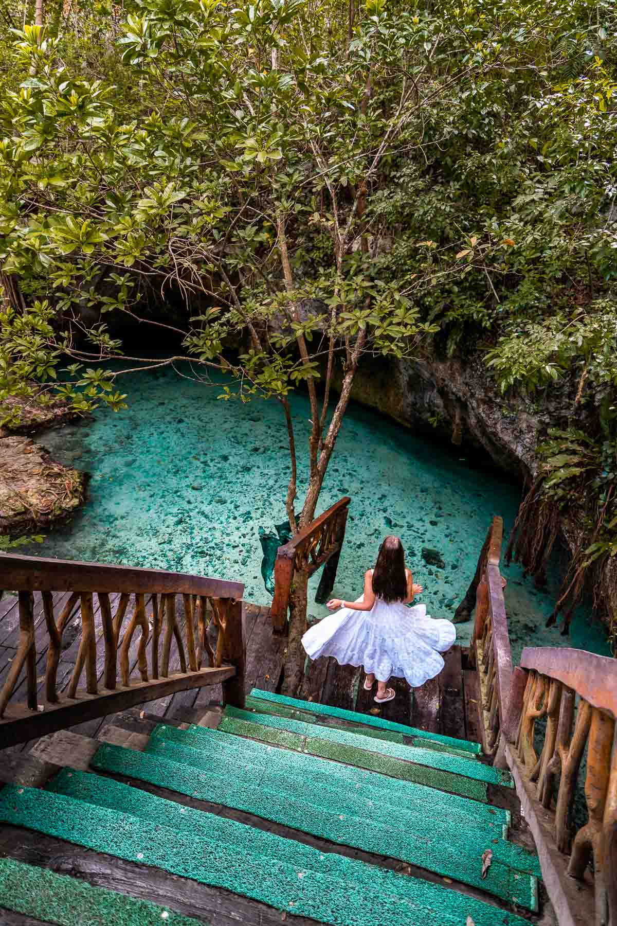 Girl in white dress on the stairs at Gran Cenote