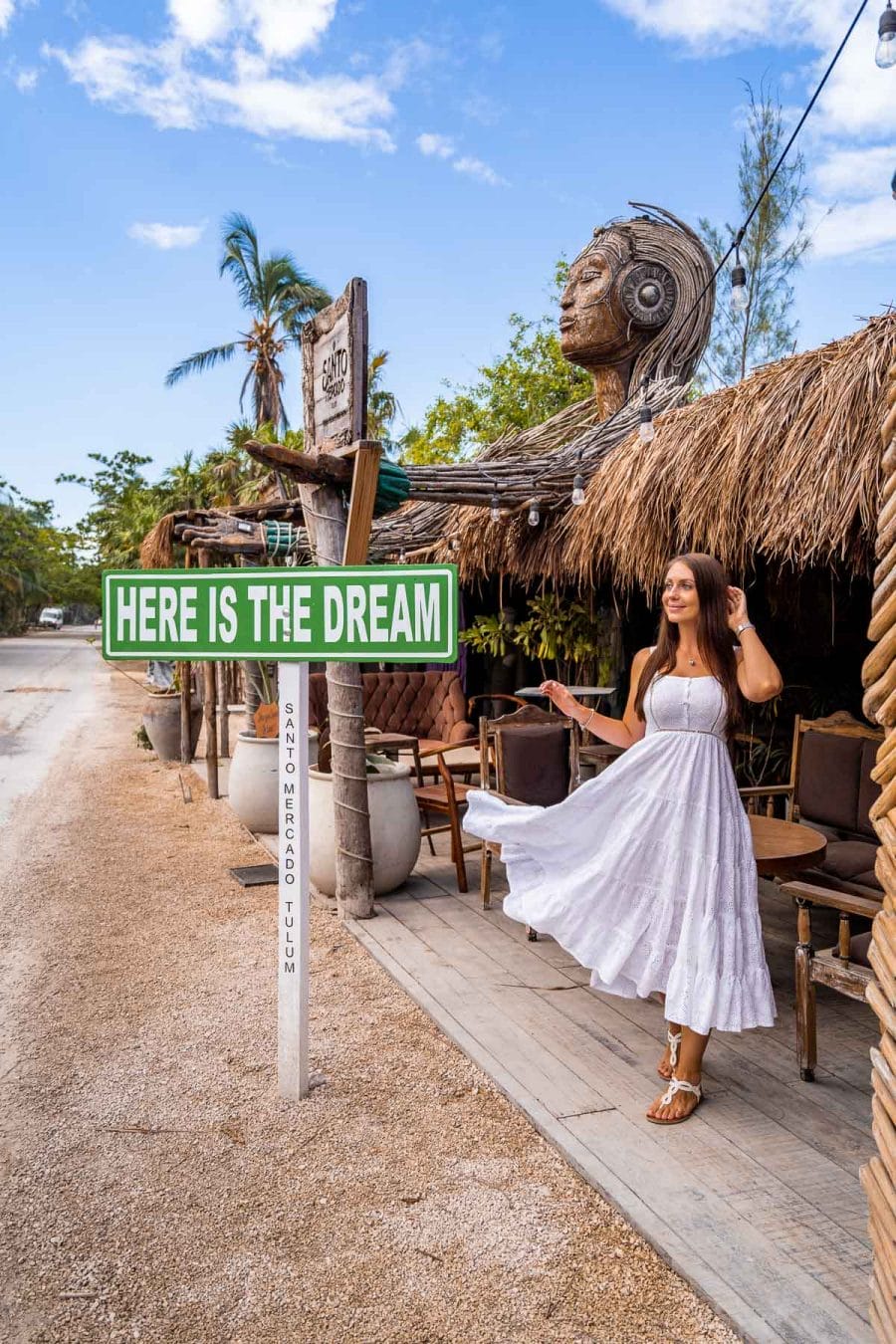 Girl in white dress next to the Here is the Dream Sign in Tulum