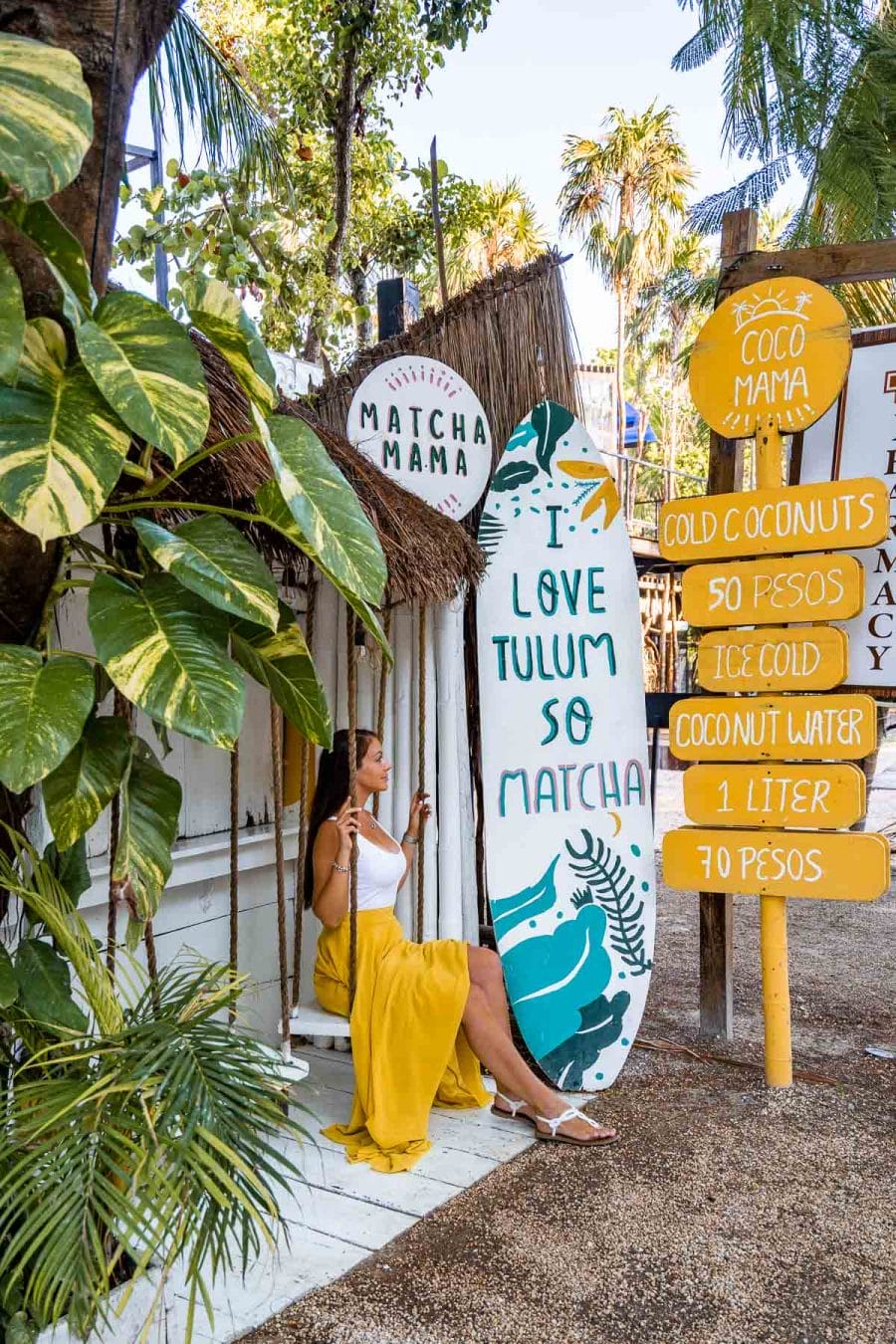 Girl in yellow skirt sitting on a swing at Matcha Mama Tulum, one of the most Instagrammable places in Tulum