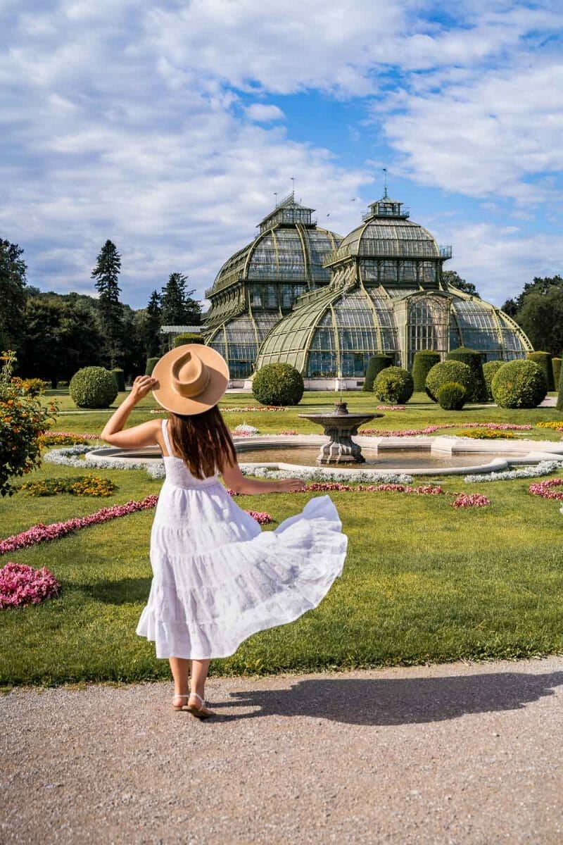Girl in a white dress in front of Palmenhaus Schönbrunn, one of the best Vienna Instagram spots