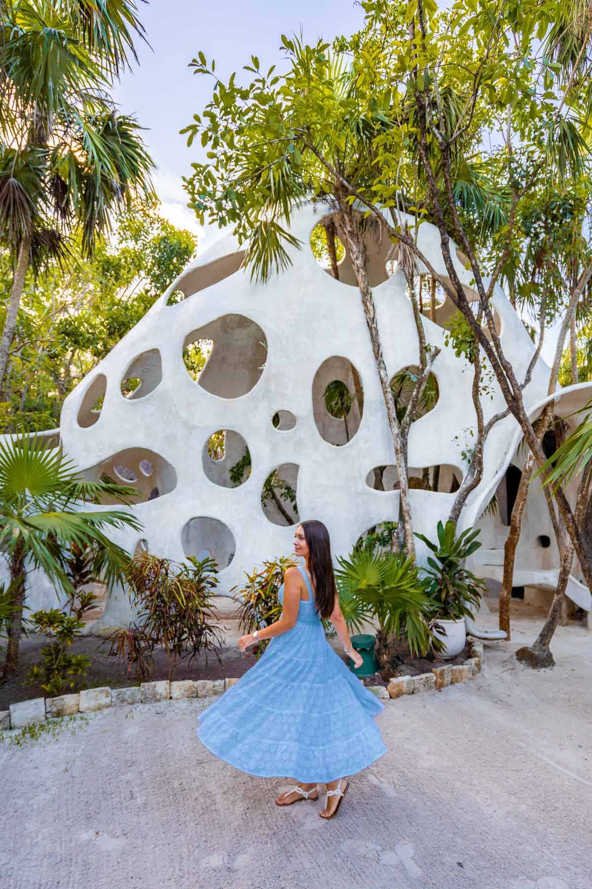 Girl in blue dress in front of the entrance of Roc Luxe Tulum
