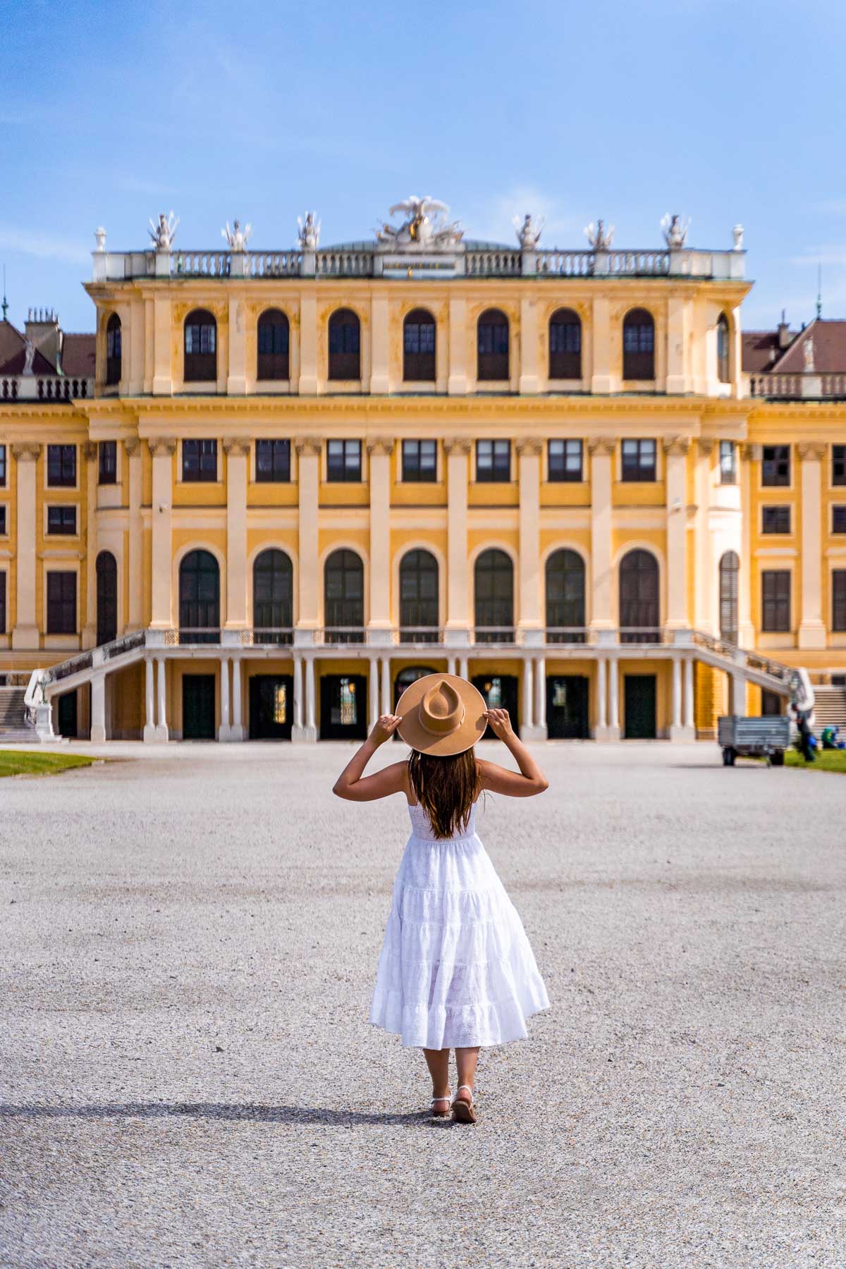 Girl in a white dress in front of the Schönbrunn Palace in Vienna, Austria