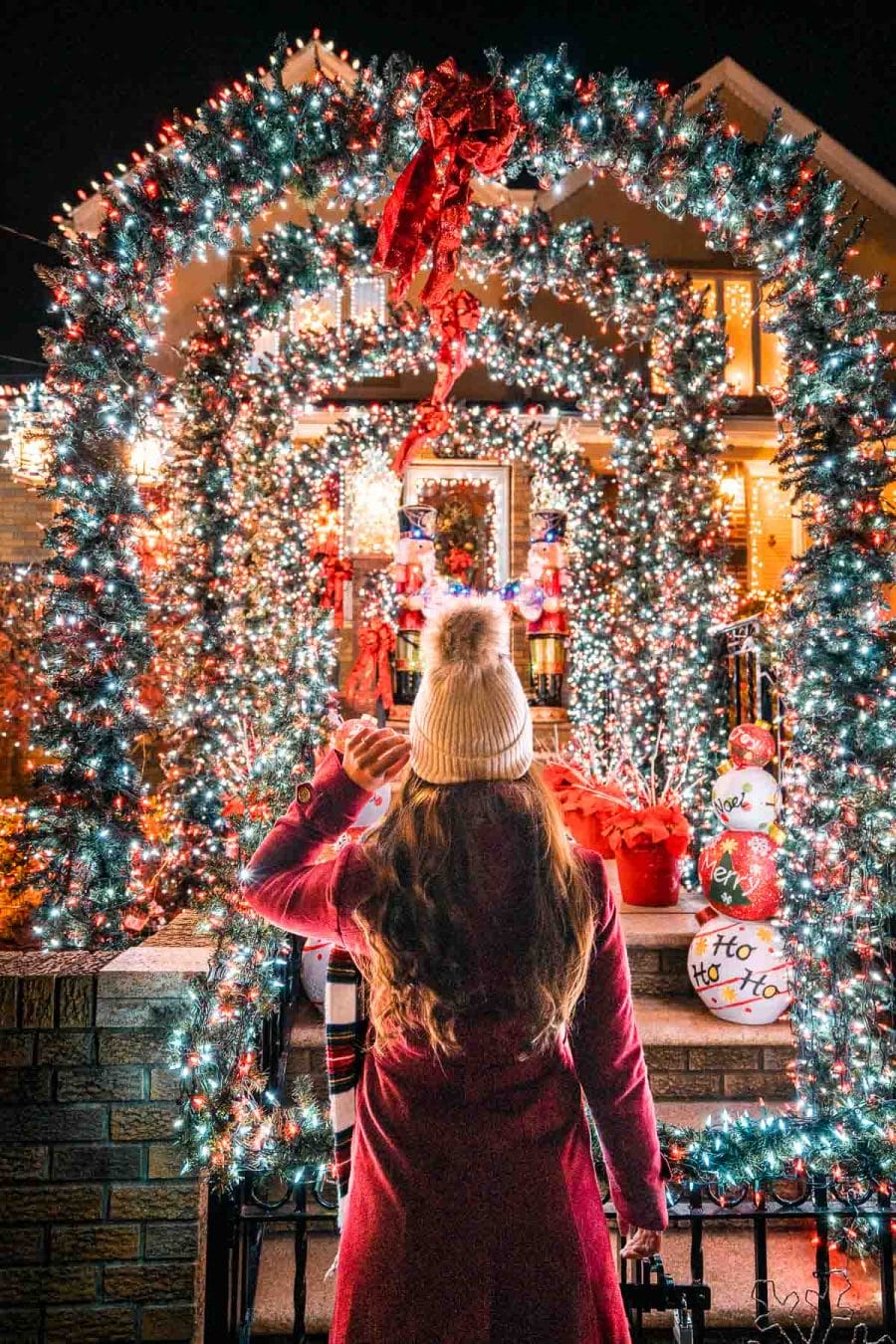Girl in red coat visiting Dyker Heights Christmas Lights