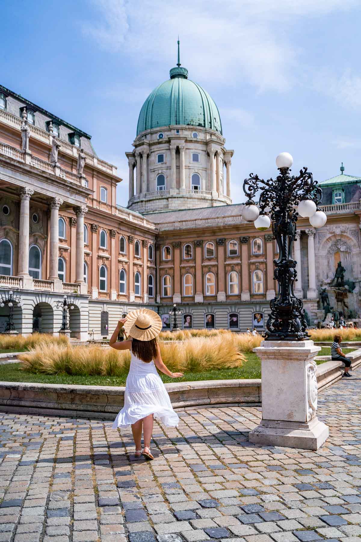 Girl in a white dress standing in front of Buda Castle