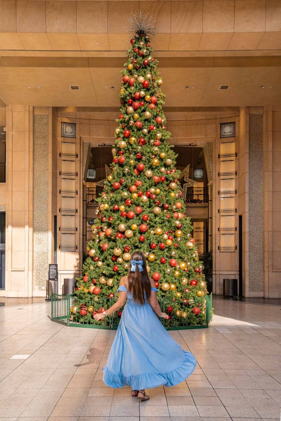 Girl in blue dress in front of the Christmas Tree at Hollywood & Highland