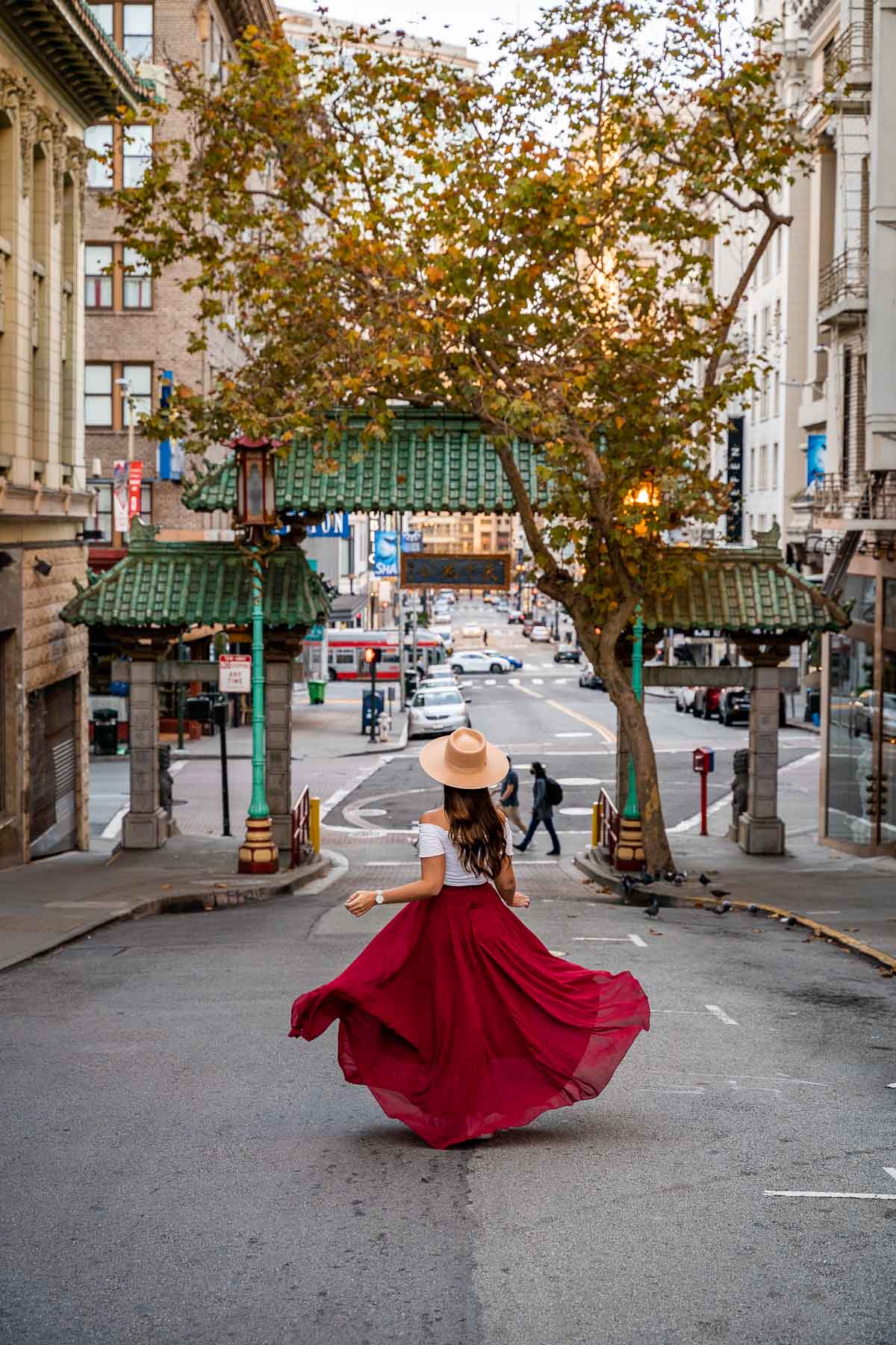 Girl in red skirt in front of the Dragon Gate in Chinatown, San Francisco