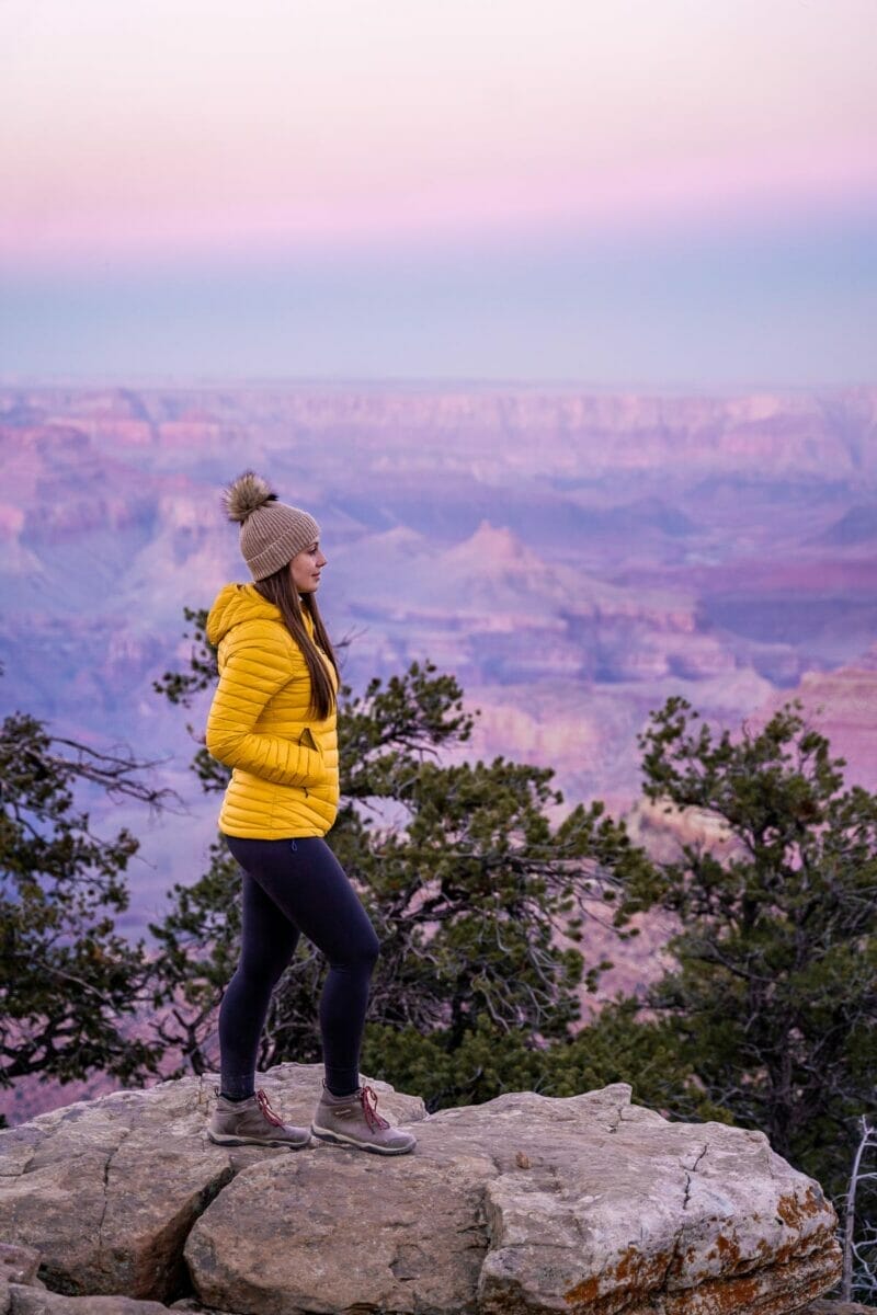 Girl in yellow jacket at the Grand Canyon at sunset