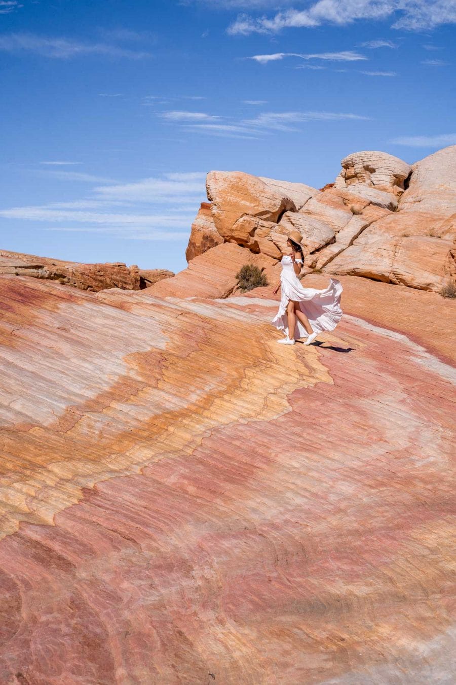 Girl in white dress at the rainbow colored Crazy Hill, one of the best Valley of Fire photography spots
