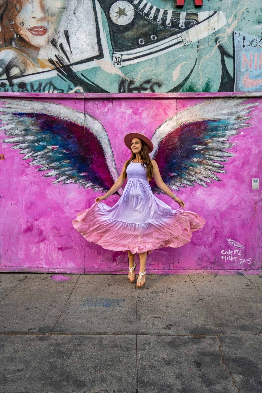 Girl in purple dress in front of the Pink Wings on Melrose Avenue, Los Angeles