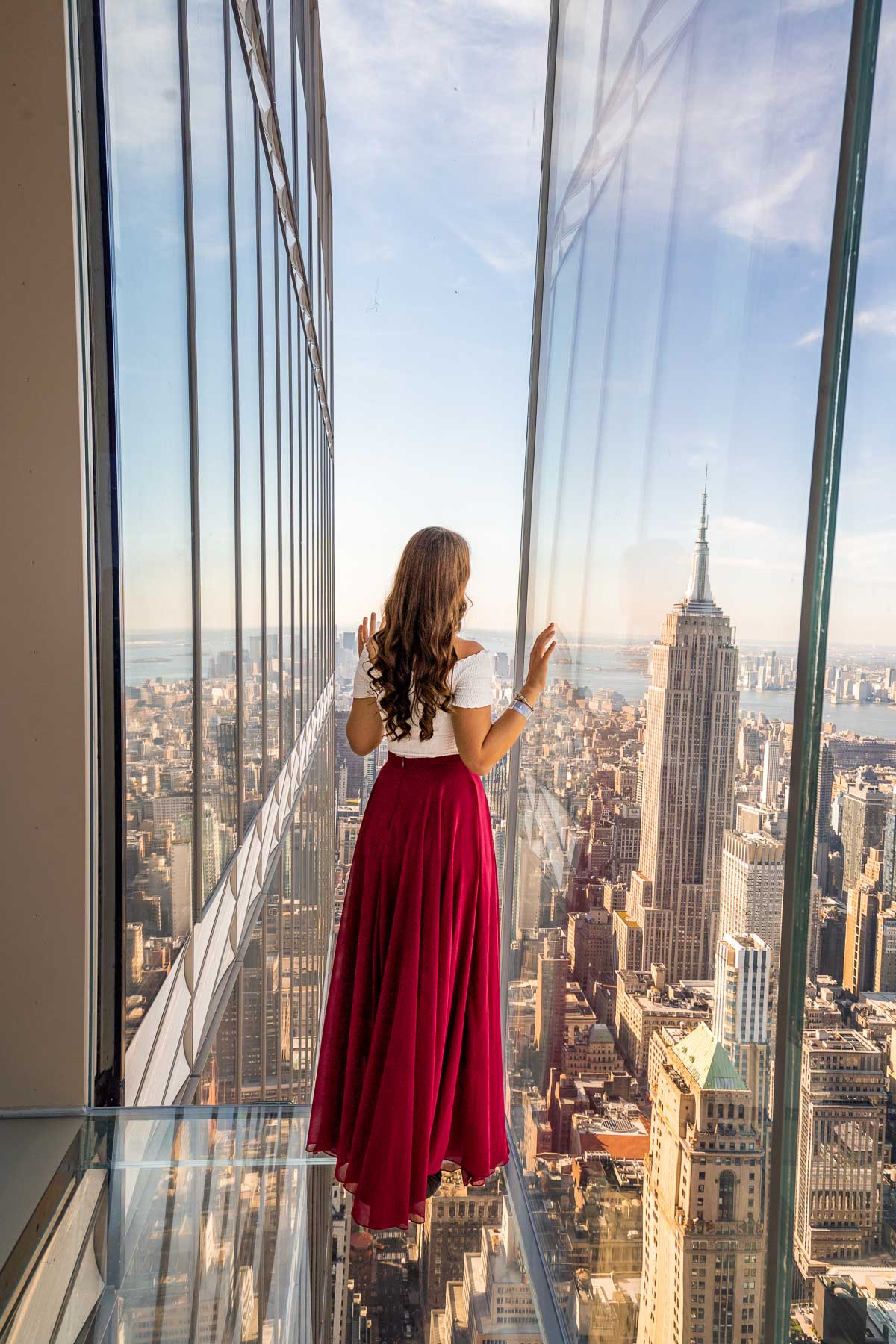 Girl in red skirt looking at the Empire State Building from SUMMIT One Vanderbilt