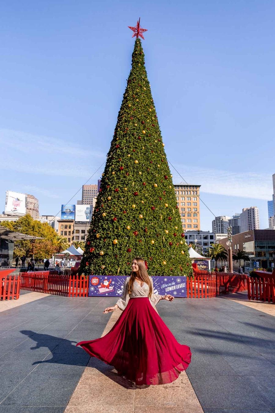 Girl in red skirt in front of a Christmas tree at Union Square, San Francisco