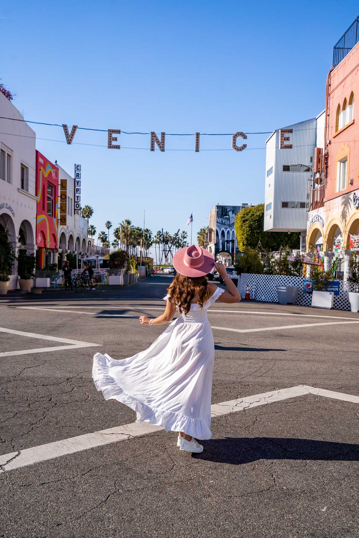 Girl in white dress at the Venice Beach Sign, one of the most Instagrammable places in LA