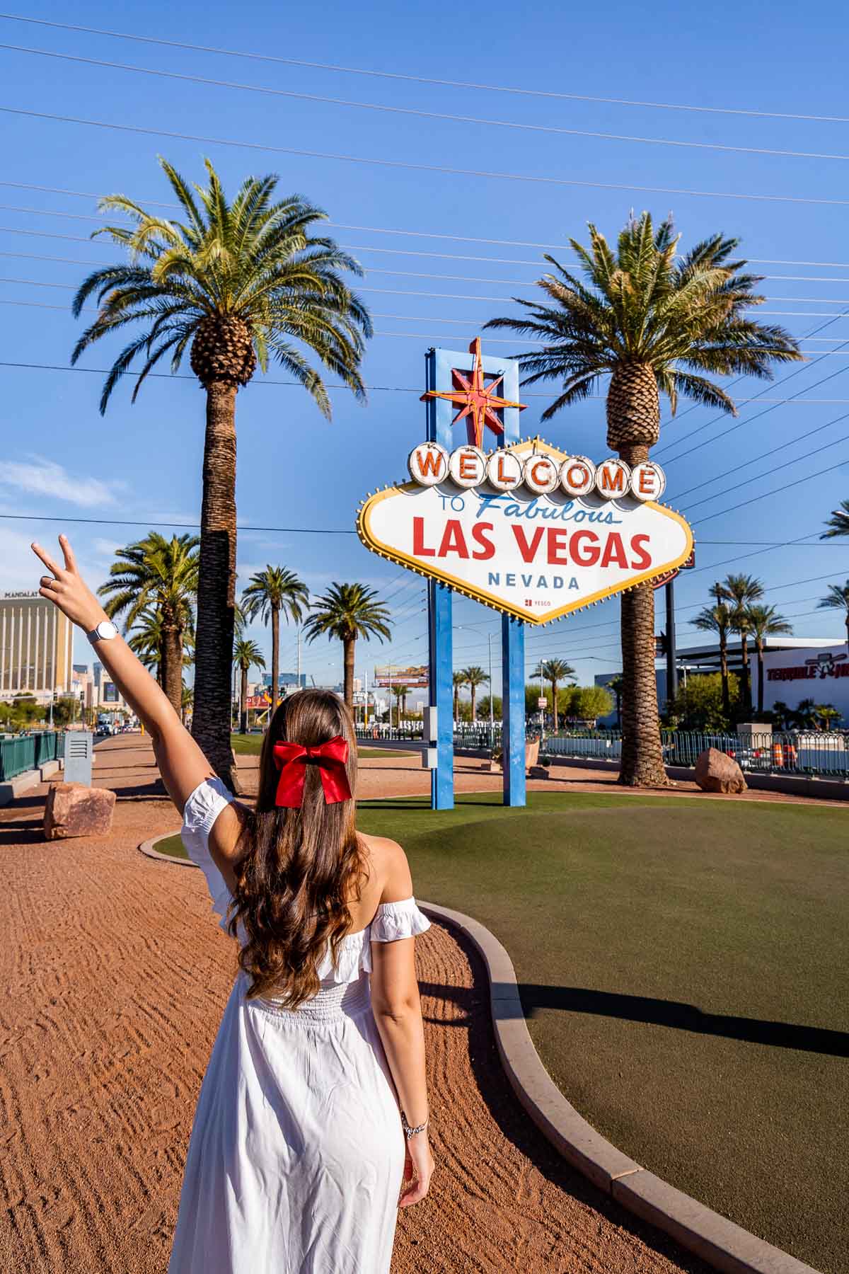 Girl in white dress in front of the Welcome to Las Vegas Sign, one of the best Las Vegas Instagram Spots