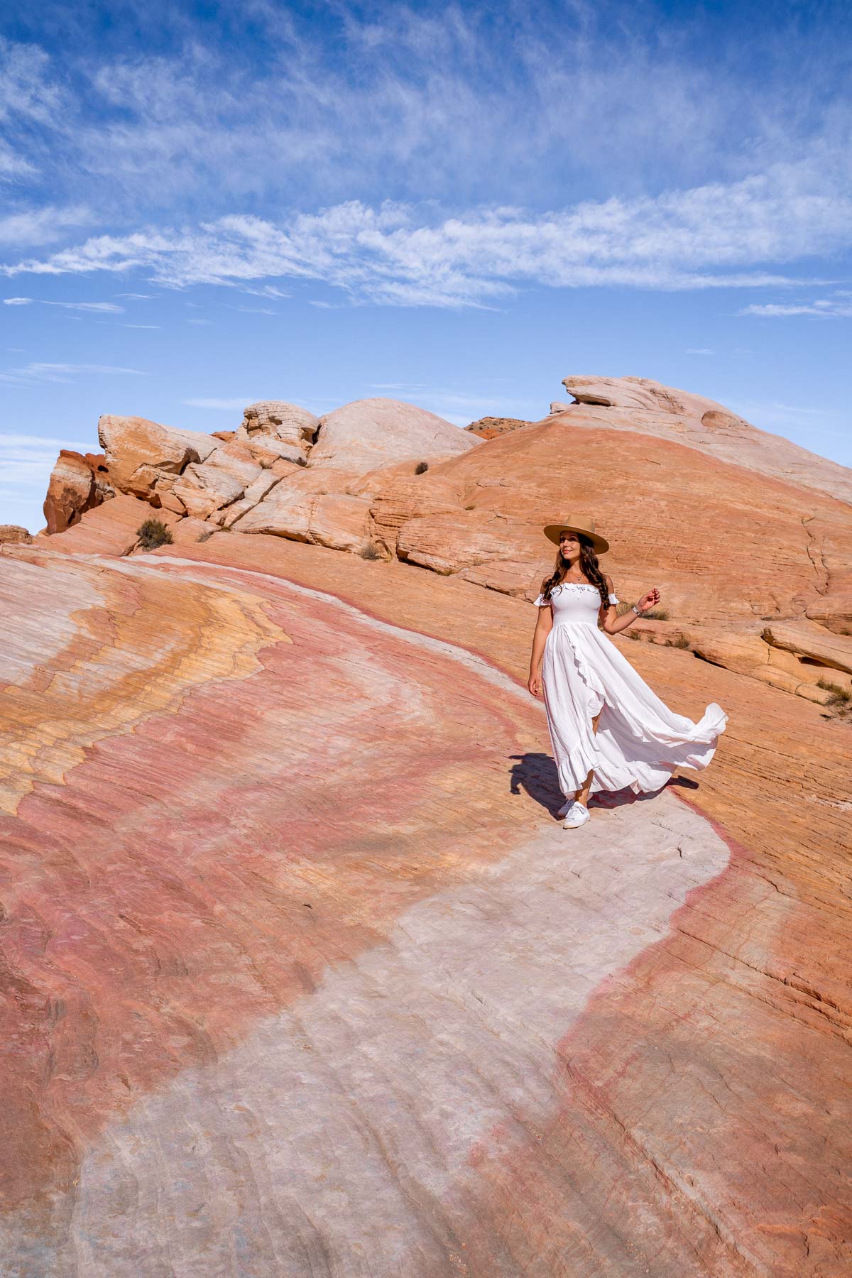 Girl in white dress at the rainbow colored Crazy Hill, one of the best Valley of Fire photography spots