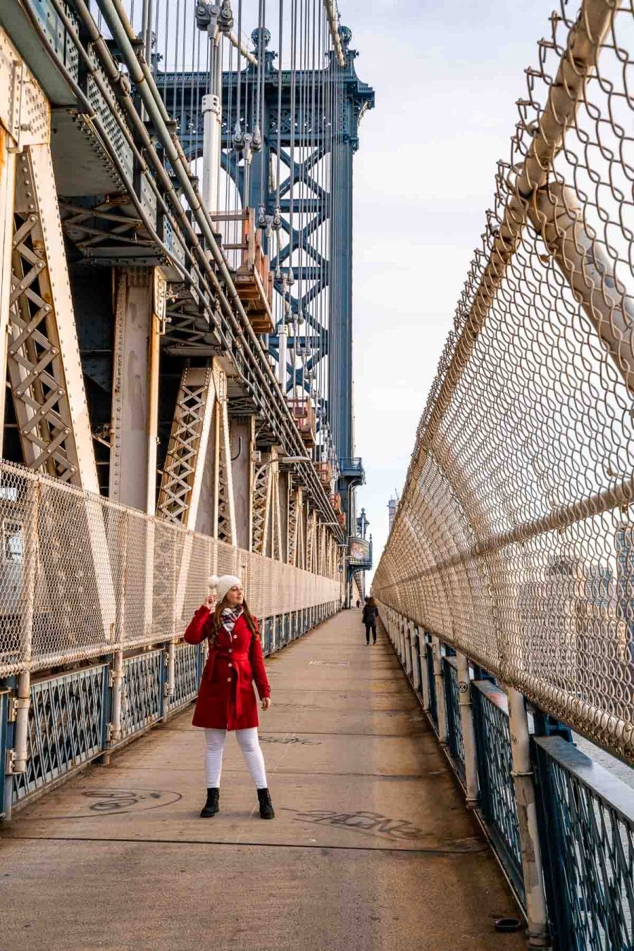 Girl in red coat standing on the Manhattan Bridge