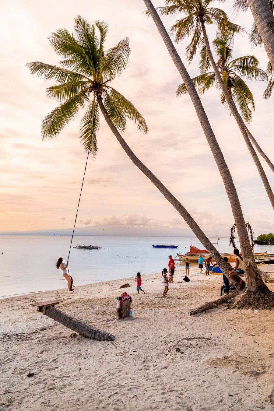 Girl swinging on a rope at Paliton Beach in Siquijor, Philippines