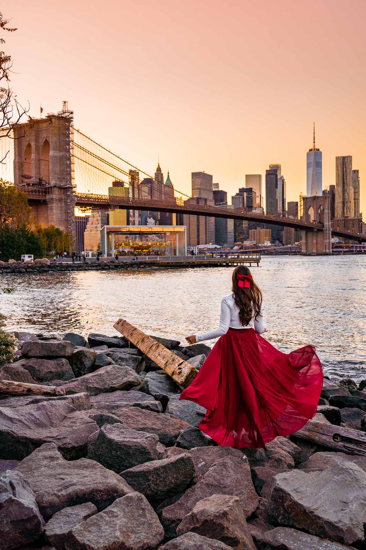 Girl in red skirt watching the sunset at Pebble Beach in New York