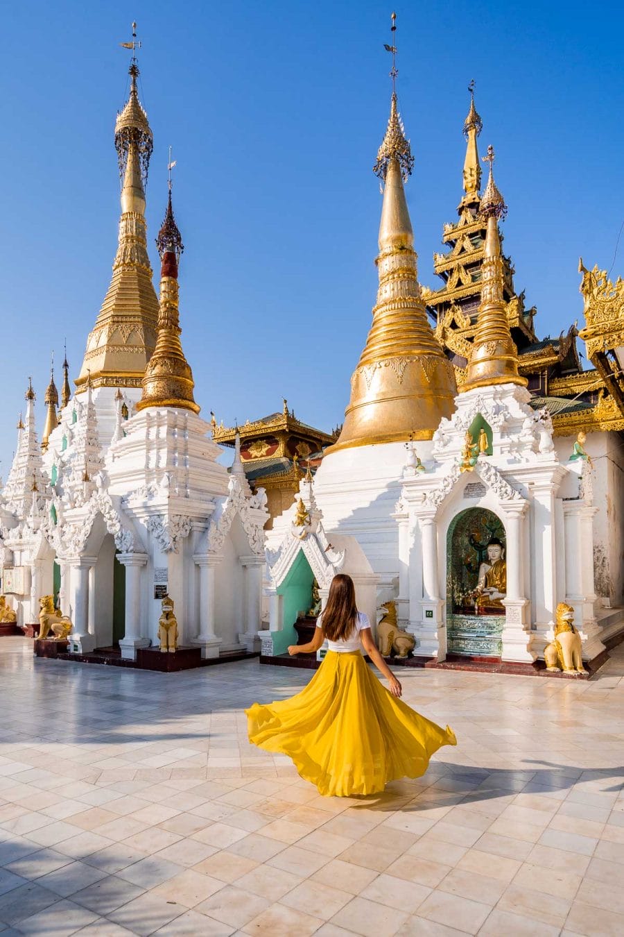 Girl in yellow skirt in front of Shwedagon Pagoda in Yangon, Myanmar