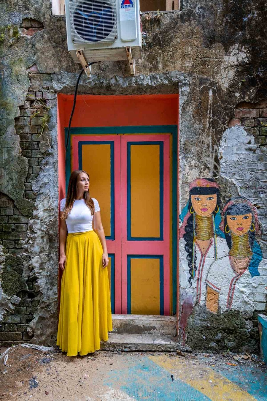 Girl in yellow skirt with murals at YGN Walls