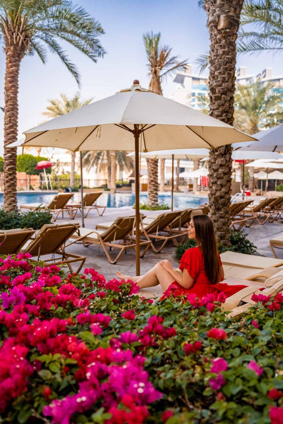 Girl in red dress sitting by the Pool at Fairmont the Palm