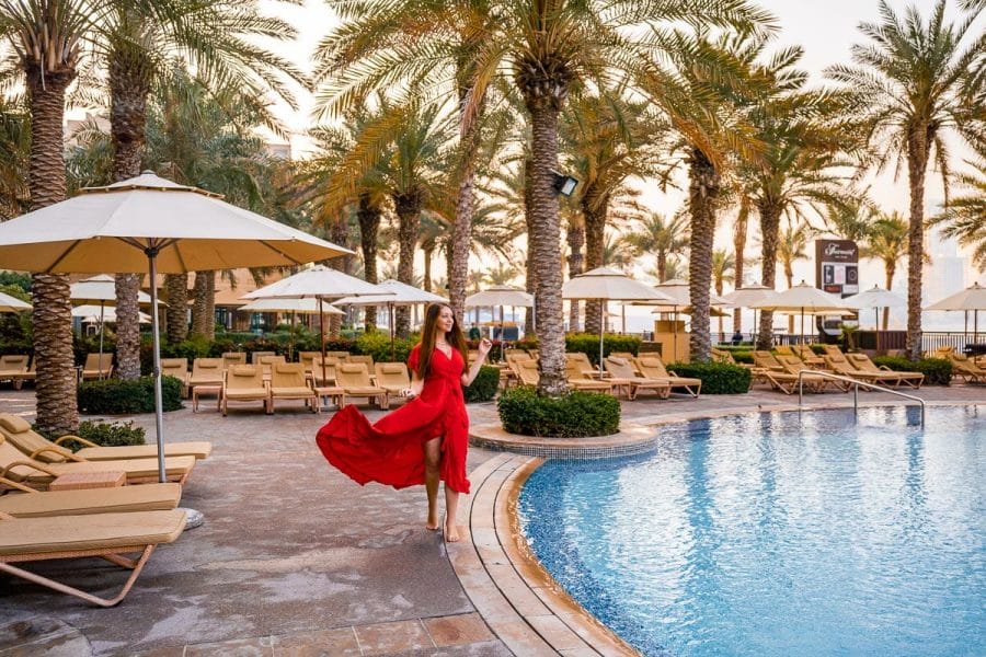 Girl in red dress standing by the Pool at Fairmont the Palm