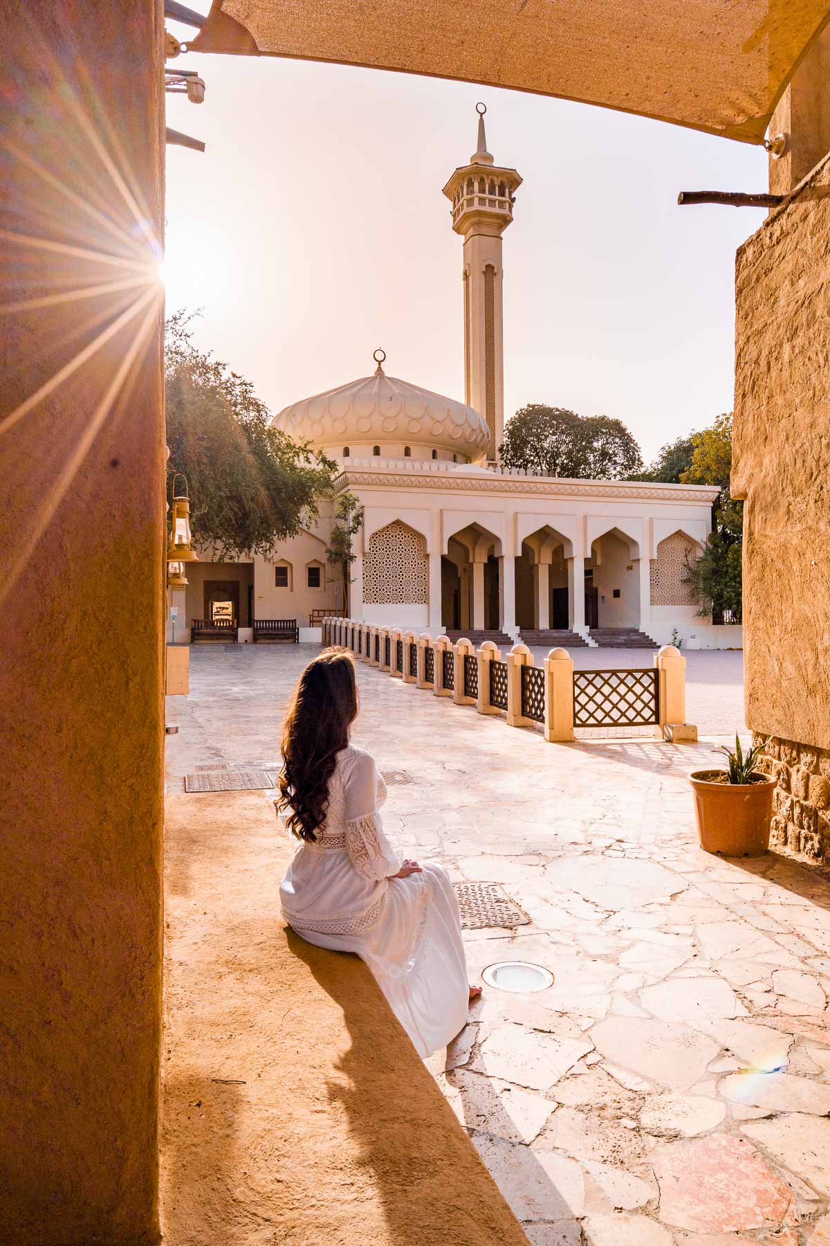 Girl sitting in front of a mosque in Al Bastakiya Dubai