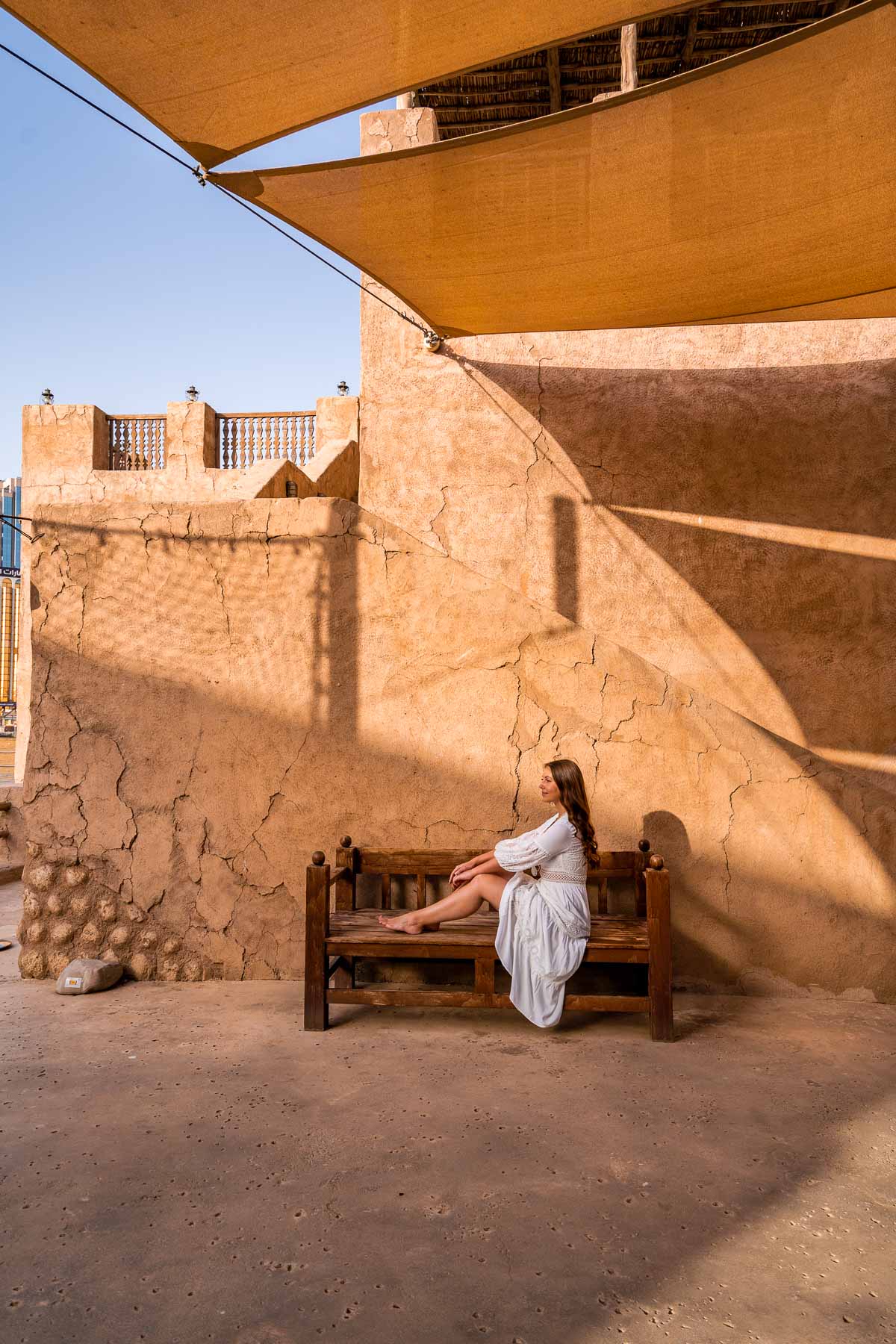 Girl sitting on a bench in Al Seef, Old Town Dubai