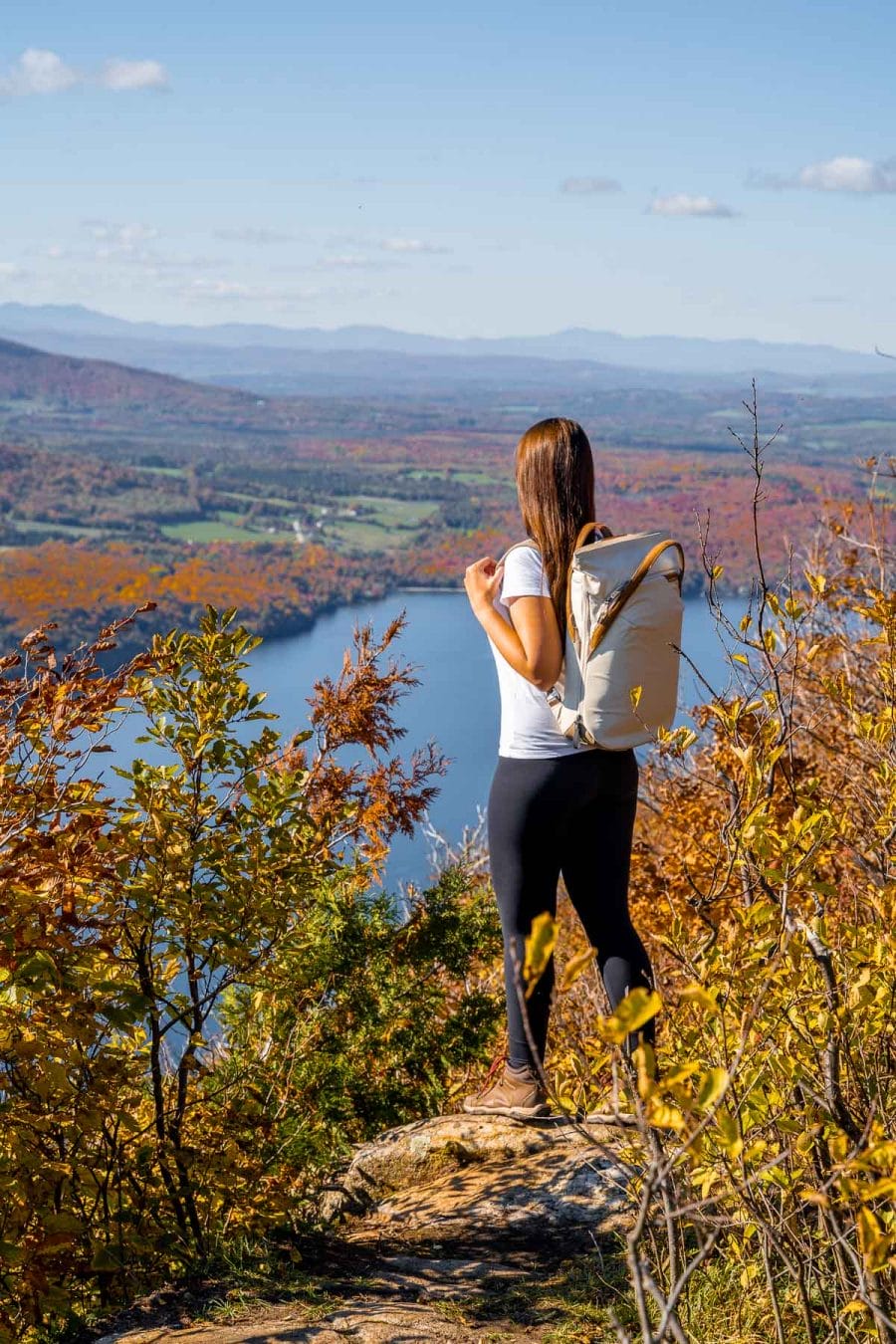 Girl on the top of Mount Pisgah, overlooking Lake Willoughby in Vermont in the fall