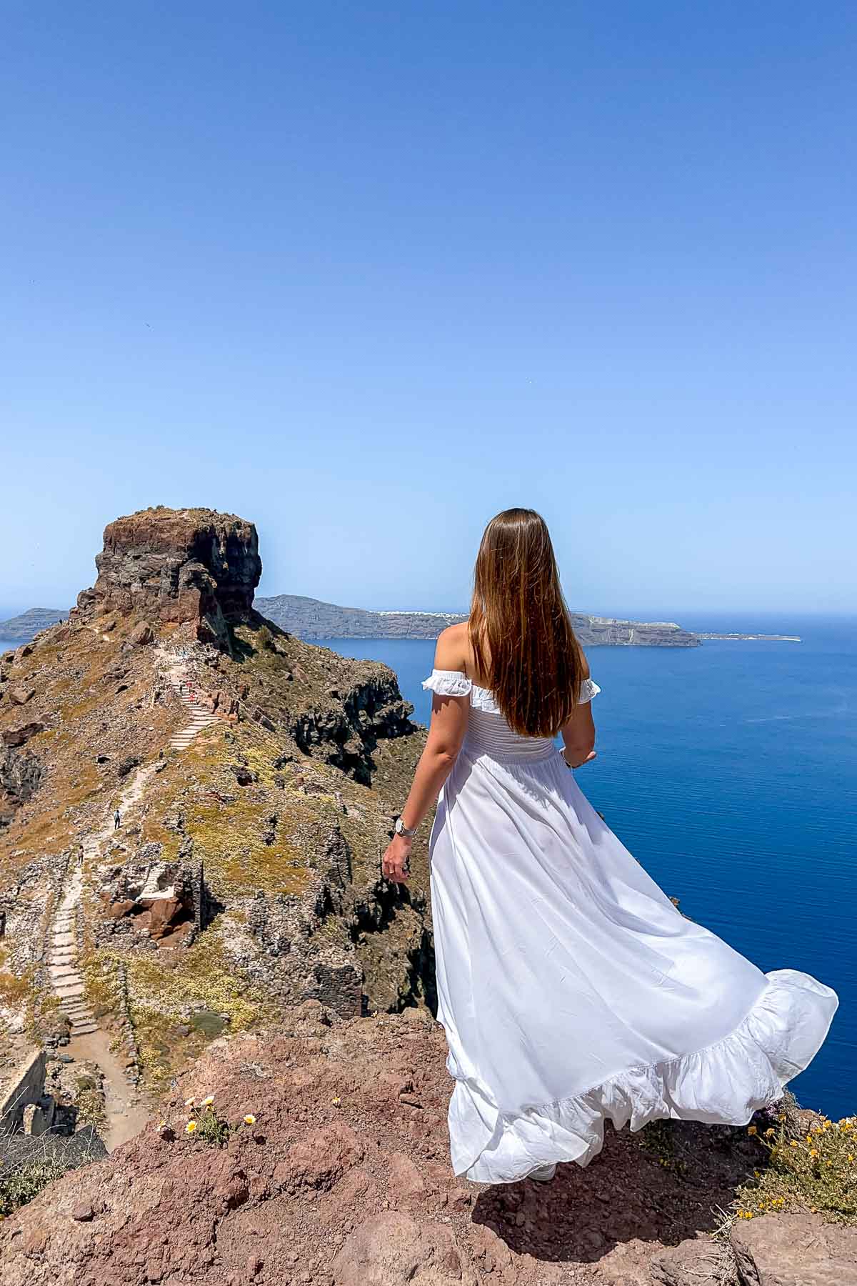 Girl in white dress at Skaros Rock in Imerovigli, Santorini