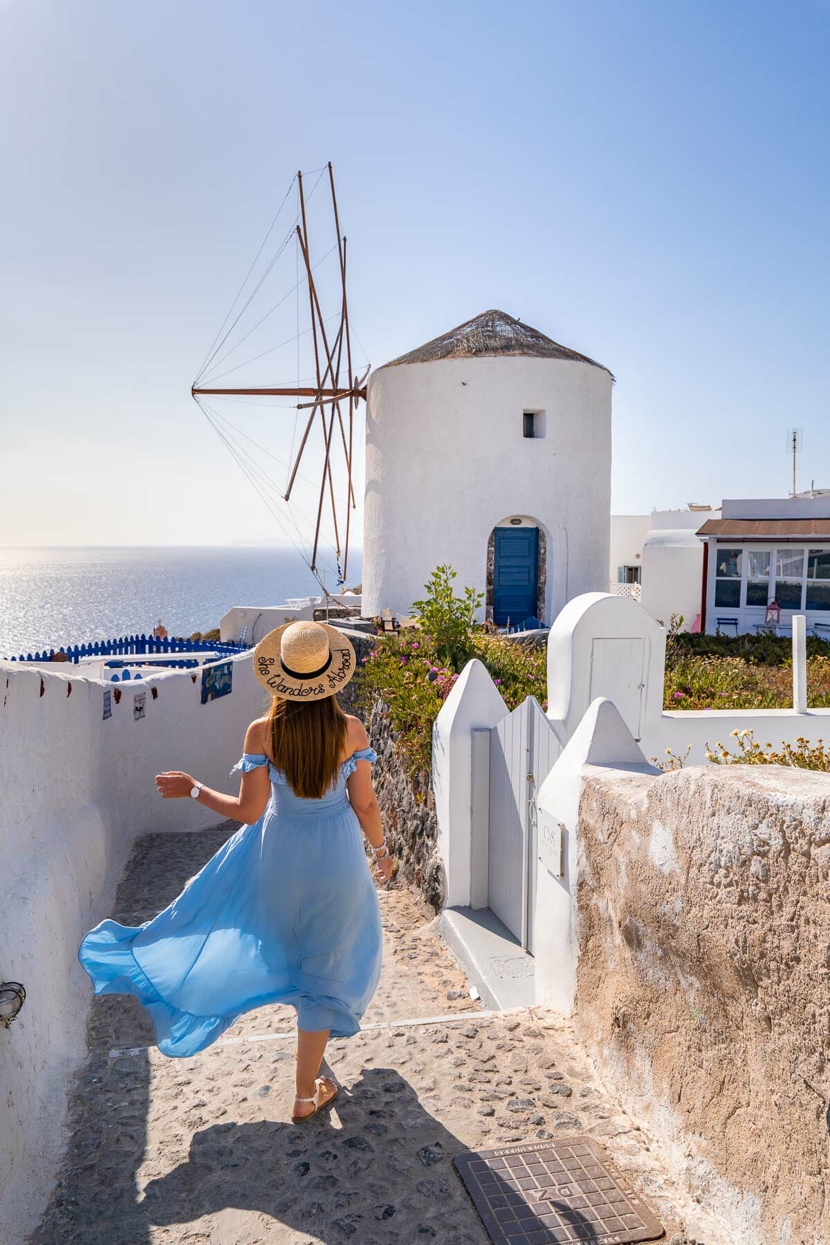 Girl in front of a windmill in Oia, Santorini