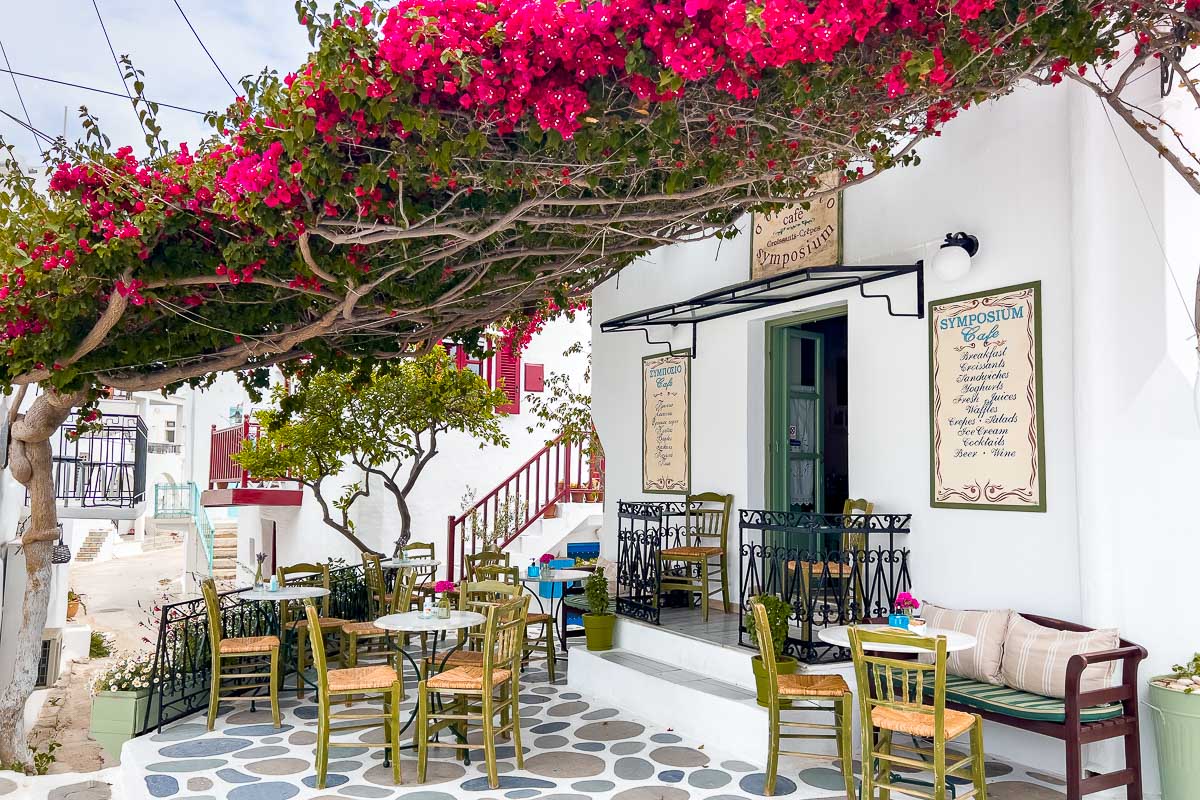 Outdoor seats under bougainvillea at Cafe Symposium, one of the best Paros restaurants