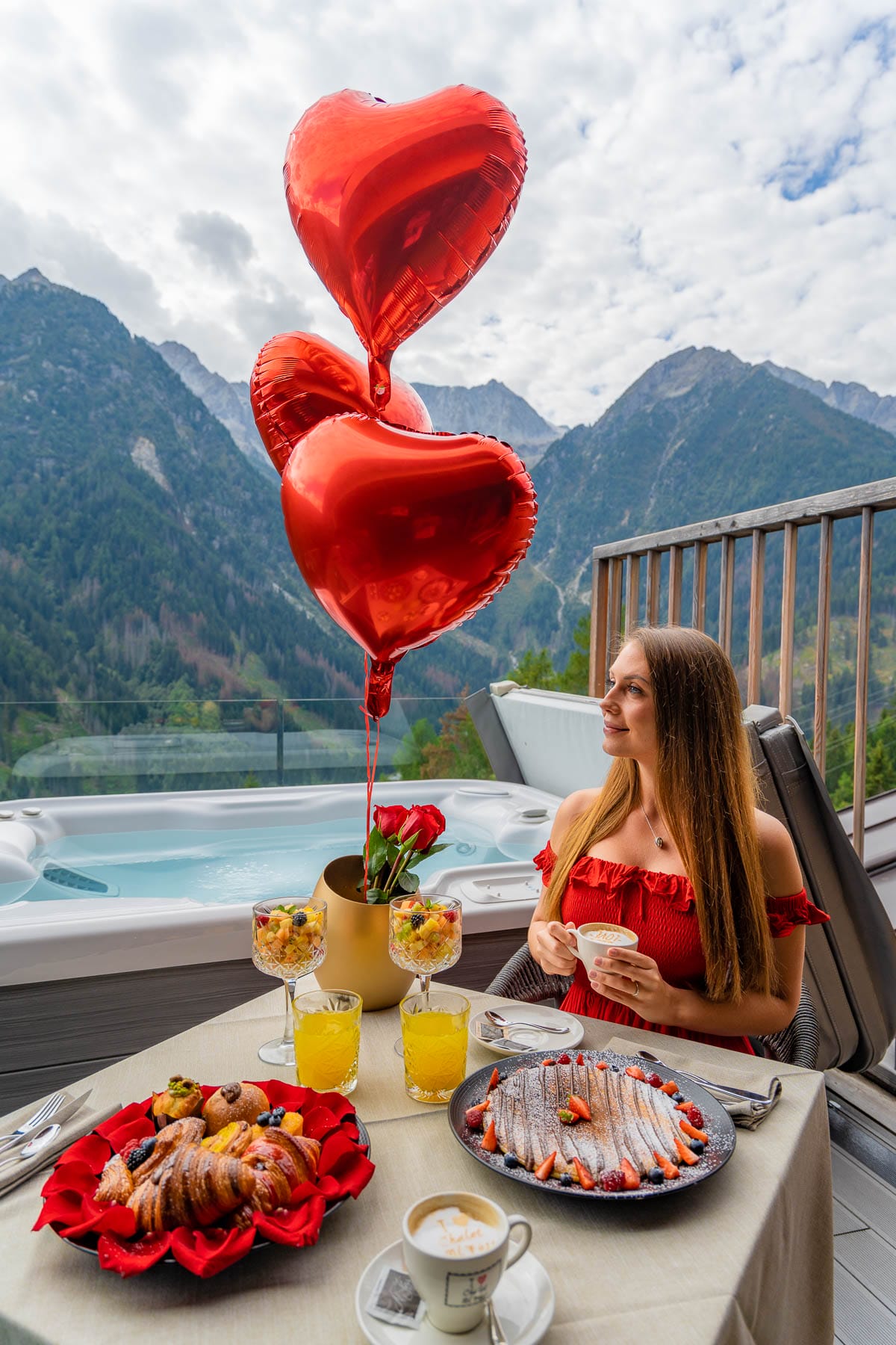 Girl with red heart shaped balloons eating breakfast at Chalet Al Foss